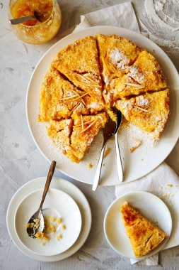 Traditional English lemon pudding cake with lemon twist and powdered sugar on a white plate