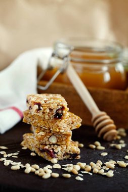 Koyu ahşap arka planda kurumuş kızılcıklı sağlıklı enerji granola çubukları.