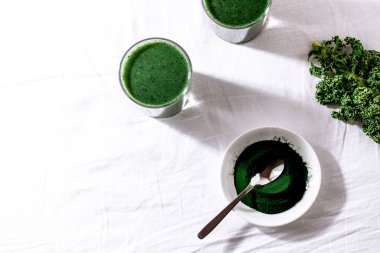 Color green spinach kale apple yogurt smoothie with spirulina on white background with shadow