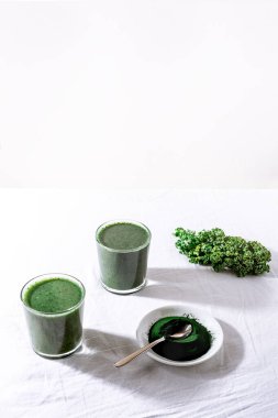 Color green spinach kale apple yogurt smoothie with spirulina on white background with shadow
