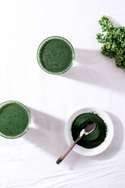 Color green spinach kale apple yogurt smoothie with spirulina on white background with shadow