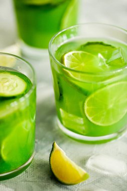 Ev yapımı buzlu kibrit yeşil çay ya da salatalık ve açık gri arka planda limonata.