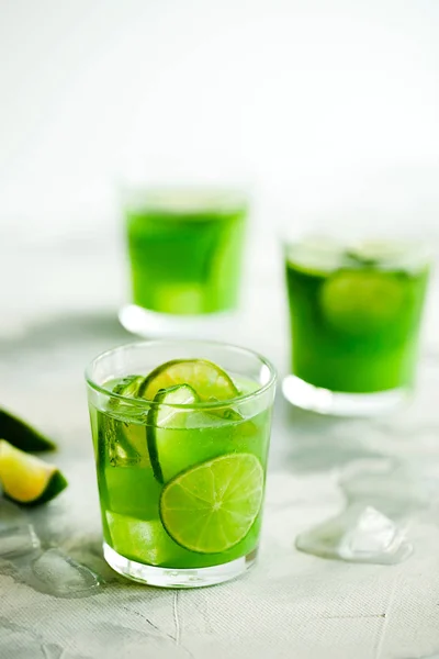 Zelfgemaakte ijsmatcha groene thee of limonade met komkommer en limoen op lichtgrijze achtergrond — Stockfoto