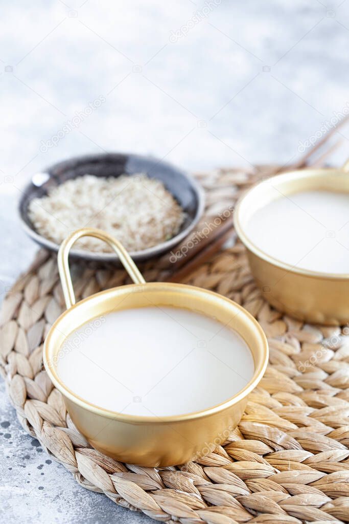 Makgeolli rice wine is one of the oldest korean traditional fermented alcoholic drinks close-up. Healthy asian boozy beverage. Vertical orientation. Selective focus