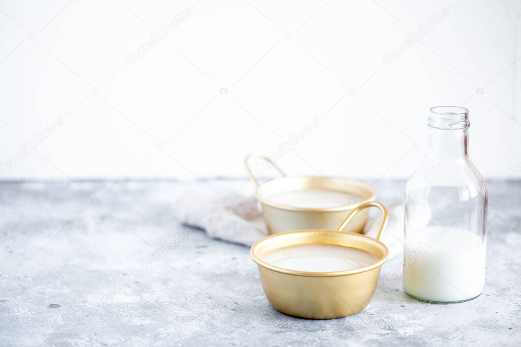 Makgeolli rice wine is one of the oldest korean traditional fermented alcoholic drinks in cup and glass bottle. Healthy asian boozy beverage. Horizontal orientation, copy space. Selective focus