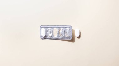 Bej arka plan düz tabaka üzerinde su toplayan haplar, tabletler veya kapsüller. Modern tıbbi tedavi, eczane, sağlık hizmetleri kavramı. Minimum soyut kompozisyon. Kopyalama alanı, yatay yönelim