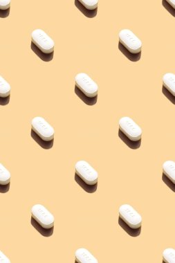 Sarı zemin üzerinde haplar, tabletler veya vitaminlerle yapılan kusursuz tıbbi şablon. Tıp sağlığı minimalistik soyut kavram. Fotoğraf kolajı