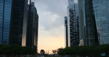 Ticari modern şirket binaları, ticari alandaki gökdelenler. Gökyüzü ve günbatımı modern bir şehirde gökdelenler arasında, gecenin neon ışıkları.