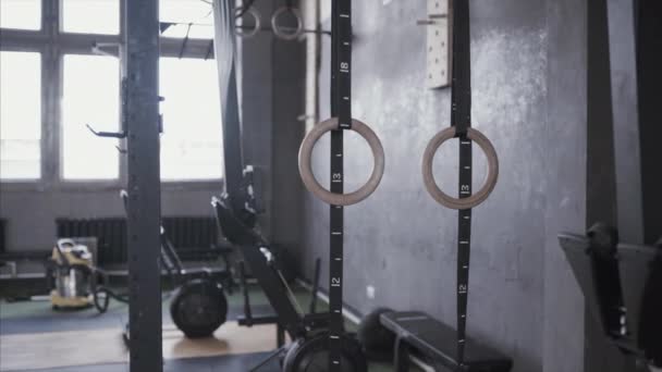 Gymnastic rings hang in gym. Training equipment for pilates and crossfit, athletics and gymnastics. — Stock Video