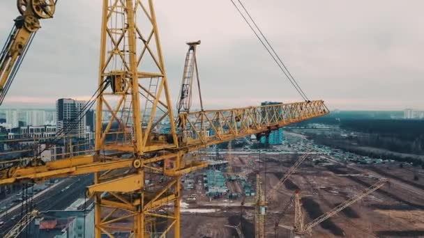 Drone flies too close to crane on construction site against backdrop of modern urban area — Stock Video