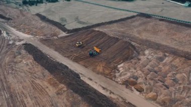 Buldozer inşaattaki kumlu bir taş ocağında kum kazıyor.