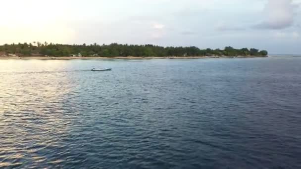 Вид с беспилотника на морское побережье с зеленью и плавучей лодкой на волнах — стоковое видео