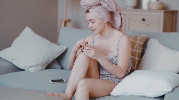 Attractive woman taking care of herself to make up for a party and a bath towel on her head. — Stok video