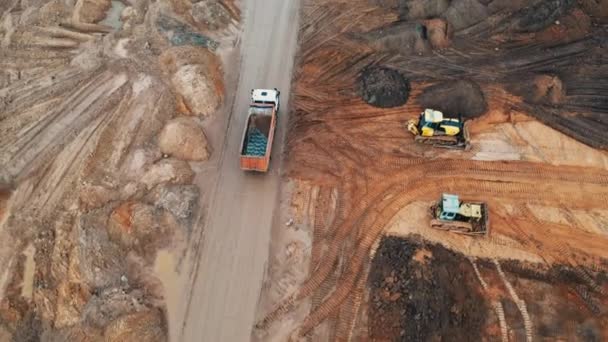 Top View drone stavební jeřáby stavět činžovní domy skládka kamiony přepravovat písek dodat beton a štěrk pro montážní práce, stavební logistika ve velkém městě na speciálním bloku byt — Stock video