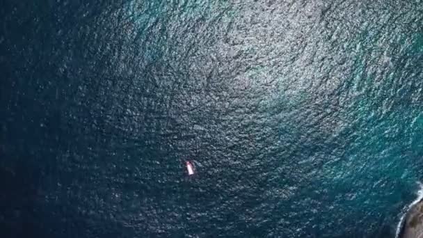 Vista superior desde arriba yate anclado barco flotando en la escorrentía del océano o crucero se encuentra en aguas azules del mar con arrecife de coral — Vídeos de Stock