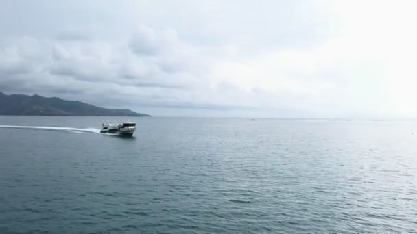 Снимаем с дрона красивую погоду со спокойным морем и светом солнца. Вид сверху на яхту, стоящую на якоре, плавающую в океанских катерах или крейсере, стоит в лазурных морских водах с видимым коралловым рифом — стоковое видео