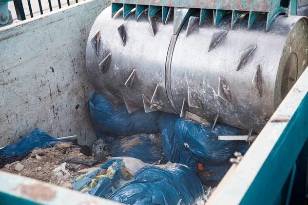 Special equipment is pressing construction waste in a container for recycling in Sorting station