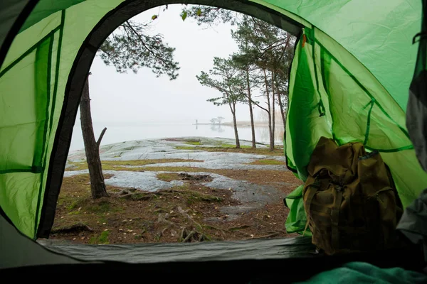 バックパック付きの観光テントの中からの眺め 森や岩場の海岸の美しい北欧の風景 フィンランド — ストック写真