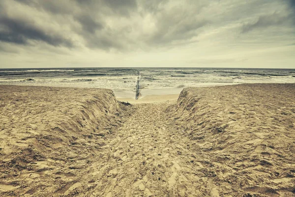 Playa retro tonificada con nubes lluviosas . — Foto de Stock
