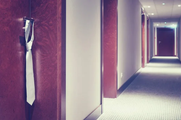 Vintage gestileerde stropdas opknoping op een hotel gesloten deur handvat — Stockfoto