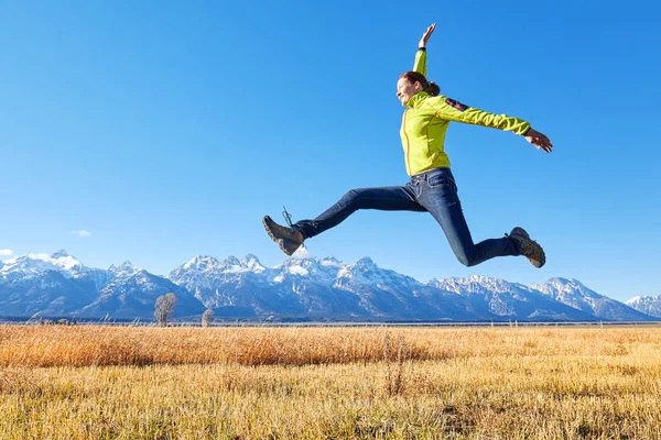 Szczęśliwa młoda kobieta, skoki na górskiej łące. — Zdjęcie stockowe