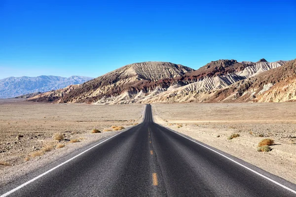 Desert road towards mountain range at Death Valley. — Stock Photo, Image