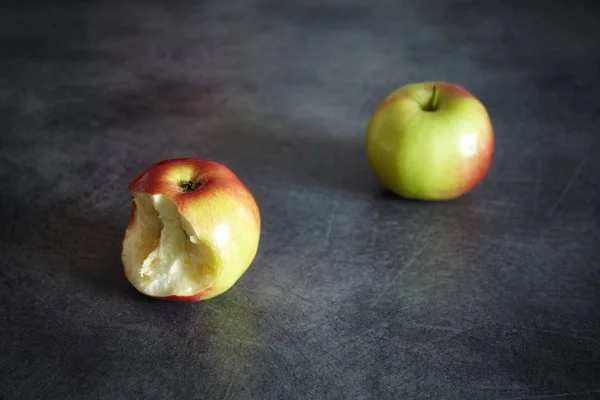 Δύο ώριμα μήλα, ένα τσίμπημα και ένα σύνολο σε σκούρο φόντο. — Φωτογραφία Αρχείου