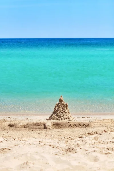 Sandburg und Krokodilskulptur am Strand. — Stockfoto