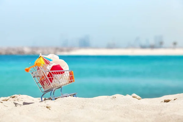 Carrito de compras en miniatura con bolsa de plástico en la playa . —  Fotos de Stock