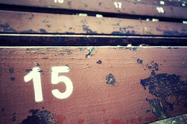 Номер пятнадцать, нарисованный на старом деревянном сидении. . — стоковое фото