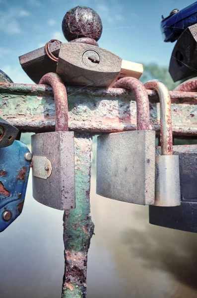 Viejos candados de amor oxidados en un puente . — Foto de Stock