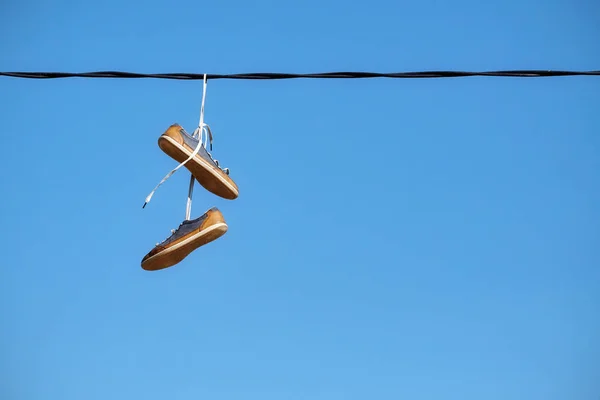 Par de sapatos velhos pendurar na linha de energia — Fotografia de Stock