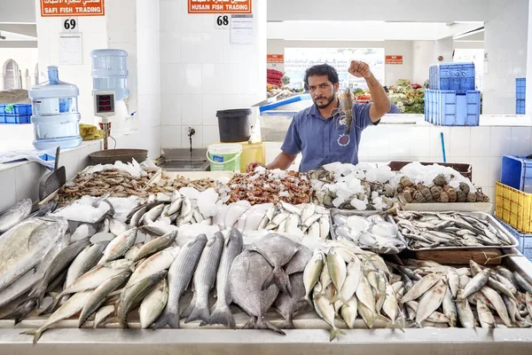 Homem vende frutos do mar no mercado de peixe local . — Fotografia de Stock