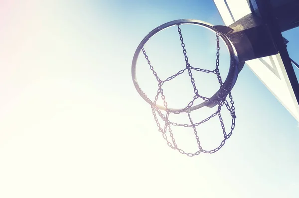 Basketbal hoepel met ketting netto bij zonsondergang. — Stockfoto