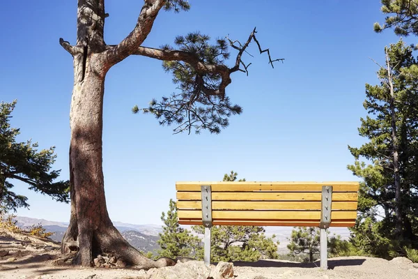 Leere Bank auf einer Klippe mit Blick auf die Berge. — Stockfoto