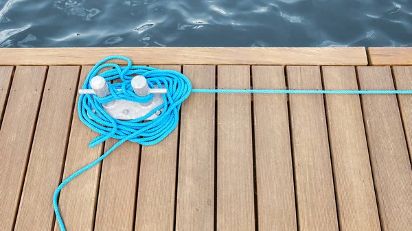 Cleat con cuerda azul en un muelle de madera . — Foto de Stock