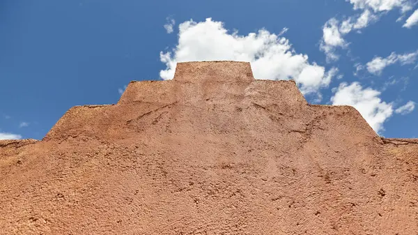 En gammal lera vägg mot blå himmel — Stockfoto