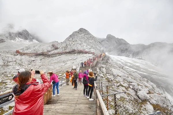Turistas en el camino hacia la plataforma de observación Jade Dragon Snow Mountain . — Foto de Stock