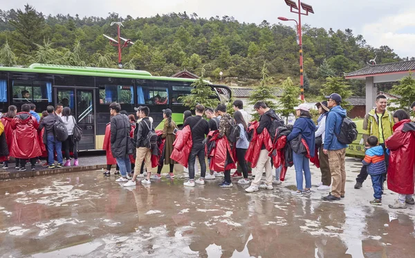 Turystów czekać w kolejce do autobusu w malowniczej okolicy Blue Moon Valley w deszczowy dzień. — Zdjęcie stockowe