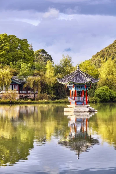 Oriental pavilion reflected in water at sunset, Lijiang, China. — Stock Photo, Image