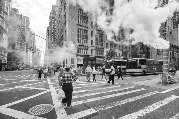 Les gens traversent la 57e rue ouest en passant par un tuyau de vapeur vaporeux . — Photo