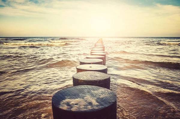 Viejo groyne de madera en una playa . — Foto de Stock