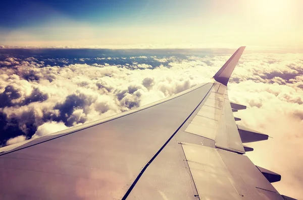 Asa de avião acima das nuvens ao pôr-do-sol . — Fotografia de Stock