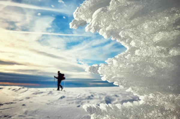 Ledové útvary při západu slunce, cross-country lyžař v dálce. — Stock fotografie