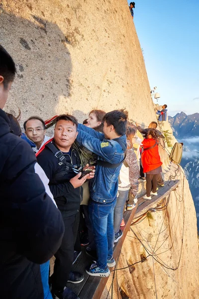 Туристы стоят в очереди на прогулку по небу, самый опасный поход в мире . — стоковое фото