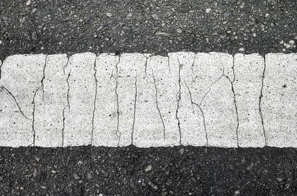 An asphalt road with a cracked white lane marking. — Stock Photo, Image