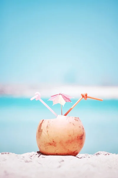 Imagen retro tonificada de una bebida de coco en una playa . — Foto de Stock