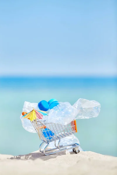 Carrinho de compras em miniatura com garrafas de plástico vazias . — Fotografia de Stock