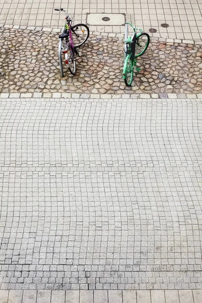 Due biciclette parcheggiate su selciato strada marciapiede . — Foto Stock
