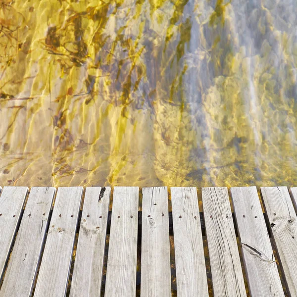 Broplanker av tre ved et vann – stockfoto